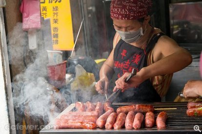 進入平溪的橫街窄巷，就會找到多檔售賣即烤香腸的店子，香氣與熱氣四射，最好用天涯鏡遠距拍攝，放大了的肉腸令人食慾大增，而老闆的烤腸功夫也看得清清楚楚，是味覺和視覺享受。(52mm、ISO 800、f/6.3、1/120s)