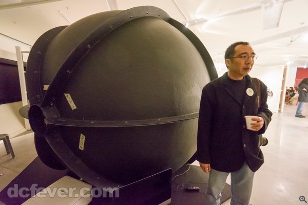 John 在城大的展覽站在 iDoom 旁邊，可以看到該球形屏幕的體積。